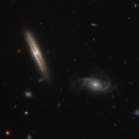 Despite its unassuming appearance, the edge-on spiral galaxy captured in the left half of this NASA/ESA Hubble Space Telescope image is actually quite remarkable. Located about one billion light-years away in the constellation of Eridanus, this striking galaxy — known as LO95 0313-192 — has a spiral shape similar to that of the Milky Way. It has a large central bulge, and arms speckled with brightly glowing gas mottled by thick lanes of dark dust. Its companion, sitting pretty in the right of the frame, is known rather unpoetically as [LOY2001] J031549.8-190623. Jets, outbursts of superheated gas moving at close to the speed of light, have long been associated with the cores of giant elliptical galaxies, and galaxies in the process of merging. However, in an unexpected discovery, astronomers found LO95 0313-192 to have intense radio jets spewing out from its centre! The galaxy appears to have two more regions that are also strongly emitting in the radio part of the spectrum, making it even rarer still. The discovery of these giant jets in 2003 — not visible in this image, but indicated in this earlier Hubble composite — has been followed by the unearthing of a further three spiral galaxies containing radio-emitting jets in recent years. This growing class of unusual spirals continues to raise significant questions about how jets are produced within galaxies, and how they are thrown out into the cosmos.
